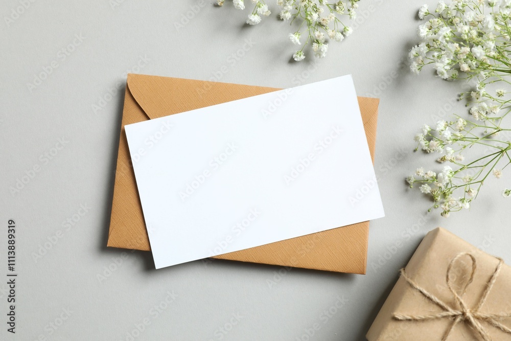 Top view photo with gypsophila flowers, paper card and gift box on gray background Top view photo with gypsophila flowers, paper card and gift box on gray background