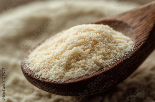 Close-up of a wooden spoon filled with a beige powder such as moringa or spice. photo