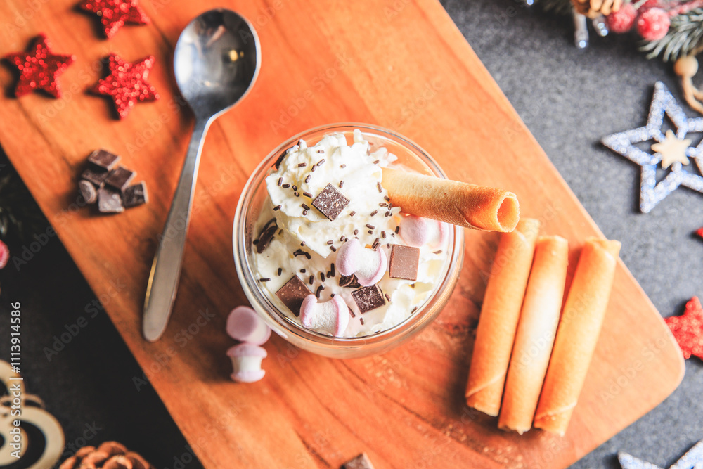 Traditional hot chocolate with whipped cream, marshmallows and chocolate shavings in a Christmas decoration
