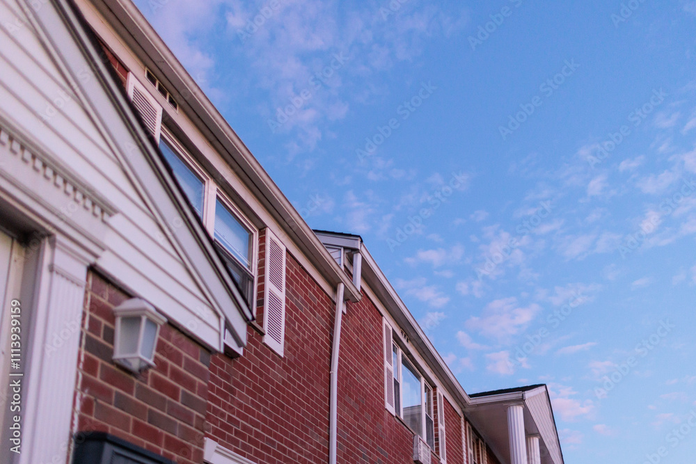 Brick building exterior against a blue sky. Low angle view showcasing architecture details and a peaceful setting. Brick building exterior against a blue sky. Low angle view showcasing architecture details and a peaceful setting.