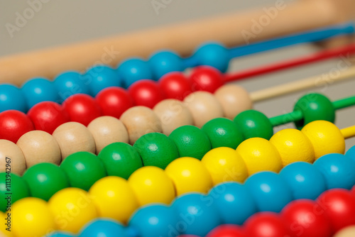 Colorful abacus beads, close-up view.  Bright primary colors arranged in rows on a wooden frame. Ideal for education and math concepts.