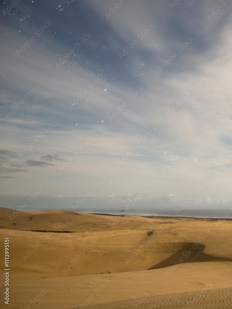 Starry night sky over smooth desert dunes under a twilight gradient, Te Paki Sand Dunes, Northland, New Zealand Starry night sky over smooth desert dunes under a twilight gradient, Te Paki Sand Dunes, Northland, New Zealand