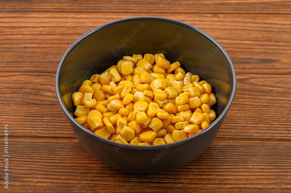 Close-up of vibrant yellow corn kernels in a sleek black clay bowl on a rustic wooden background, creating an appetizing and colorful presentation of this nutritious vegetable Close-up of vibrant yellow corn kernels in a sleek black clay bowl on a rustic wooden background, creating an appetizing and colorful presentation of this nutritious vegetable