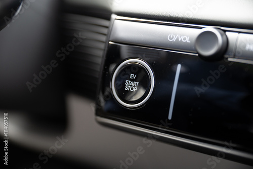 Closeup view of finger pressing the start stop button of an electric car