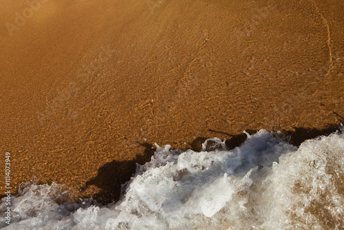 Fototapeta Naklejka Na Ścianę i Meble -  Soft sea wave rolls onto sandy beach. Red Sea. Copy space.