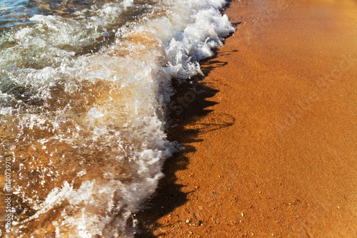 Fototapeta Naklejka Na Ścianę i Meble -  Soft sea wave rolls onto sandy beach. Red Sea. Copy space.