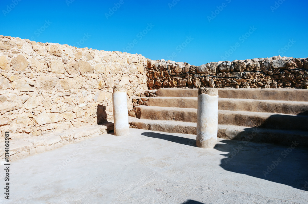 A stone wall with a stone pillar in the middle A stone wall with a stone pillar in the middle