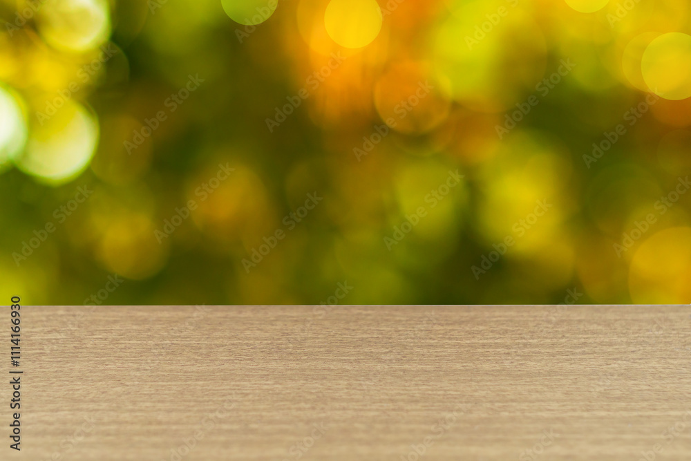 The surface of the table has a texture of light walnut, oak, hornbeam or other hardwoods, edge of table is defocused, on blurred early autumn orange-green background. Blank for design, copy space The surface of the table has a texture of light walnut, oak, hornbeam or other hardwoods, edge of table is defocused, on blurred early autumn orange-green background. Blank for design, copy space