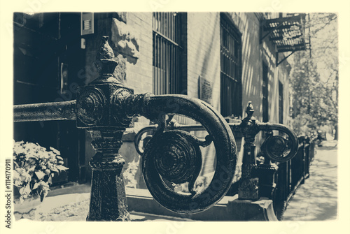 Black and white photo of a wrought iron fence with a spiral design. A View from idyllic Brooklyn Heights, Brooklyn, New York City, USA. Short depth of field.
