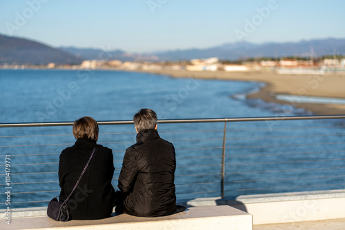 People chilling in the new waterfront built on the breakwater of the commercial port of Marina di Carrara, in Tuscany