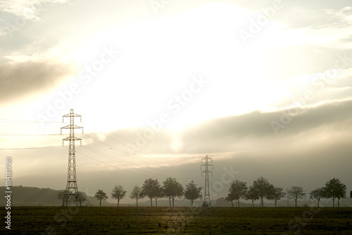 Pylônes électriques dans un paysage de campagne sous un ciel orageux photo