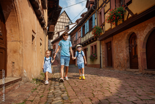 Children stroll through charming European French village street