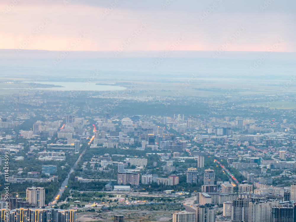 Fototapeta premium Drone view of the town at sunset. Haze covered the buildings and streets. Evening cityscape.