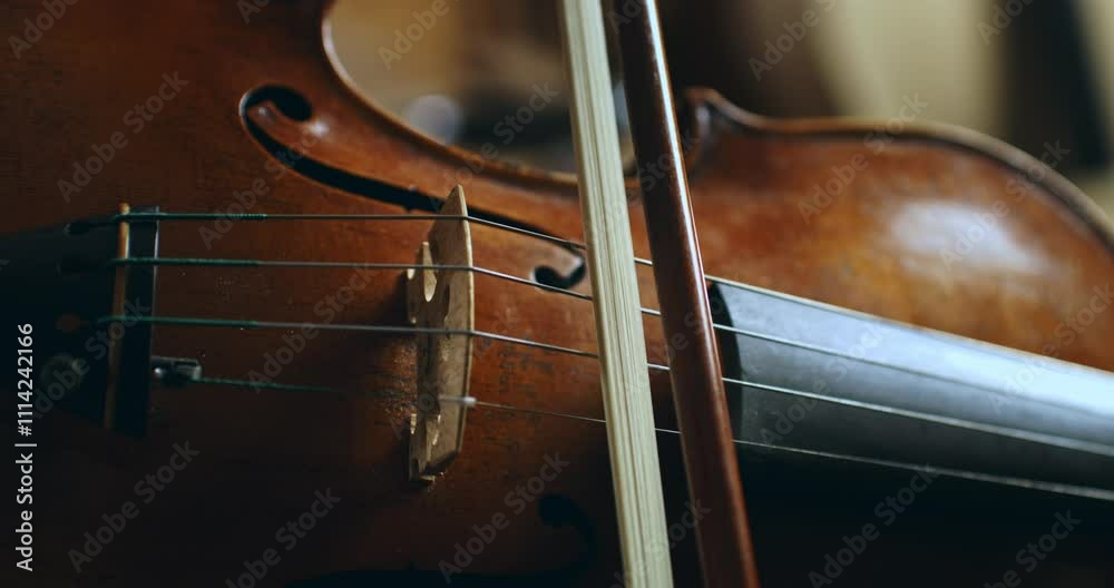 Super slow motion close up of master luthiers hands draw bow across strings of handmade violin at 1000 fps.Each movement showcase precision and artistry in both playing and craftsmanship of instrument