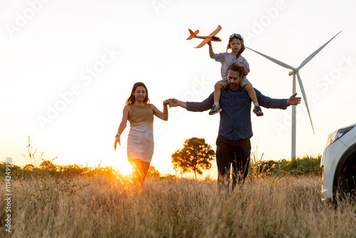 Wallpaper Mural Family with son walking on field on wind farm. Happy Family and son playing at the Wind turbines generating electricity. Family time together. Torontodigital.ca