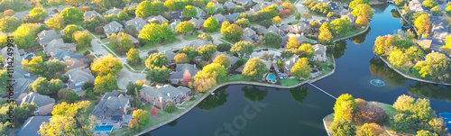 Panorama aerial view water fountain and little dam between lakeside residential area in Coppell, suburbs Dallas, Texas colorful autumn leaves row of two story large suburban houses swimming pools photo