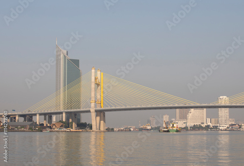 Bangkok suspension bridge over the Chao Phraya river with cityscape in background photo