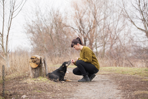 Woman walking her dog and giving her dog treats