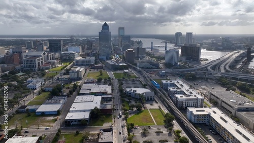 Jacksonville, Florida city skyline beside St. Johns river downtown office buildings and streets working and living in coastal town in morning light as storm front passes over