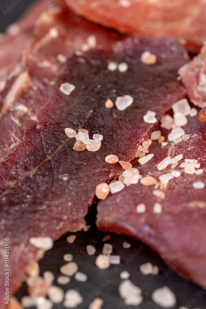 dried dried meat from meat tenderloin with spices and salt on black slate dried dried meat from meat tenderloin with spices and salt on black slate