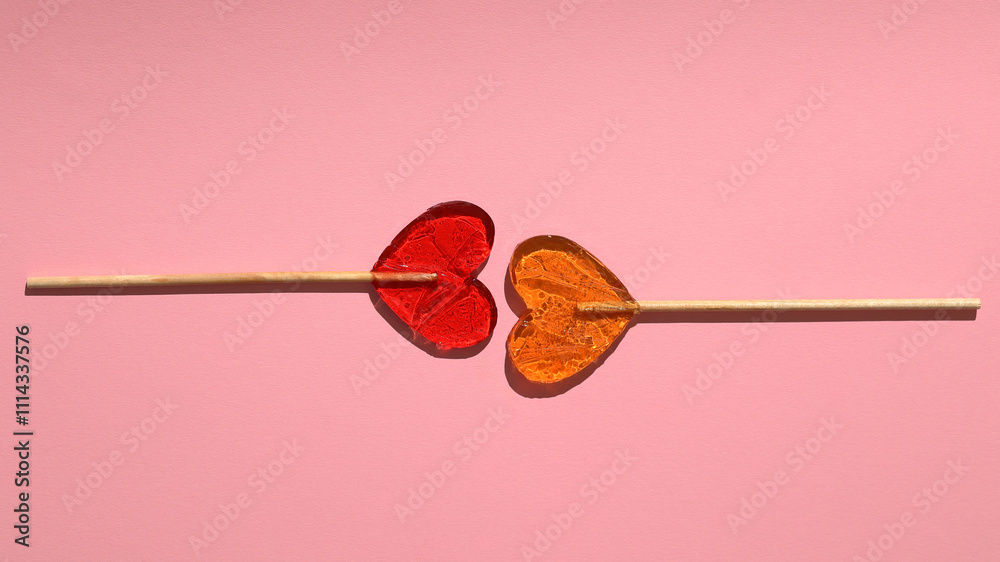 Beautiful heart-shaped lollipops lie on pink paper Beautiful heart-shaped lollipops lie on pink paper