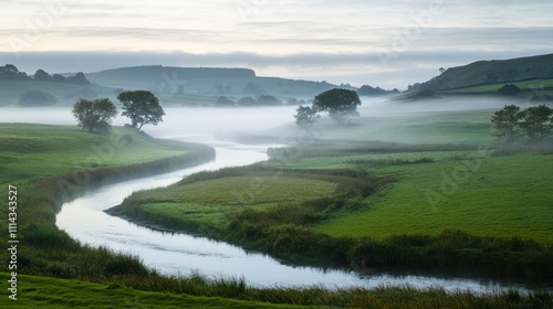 Misty green countryside with a winding river at dawn