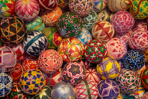 A vibrant and colorful collection of traditional Japanese Temari balls, each intricately handwoven with beautiful geometric and floral patterns. 