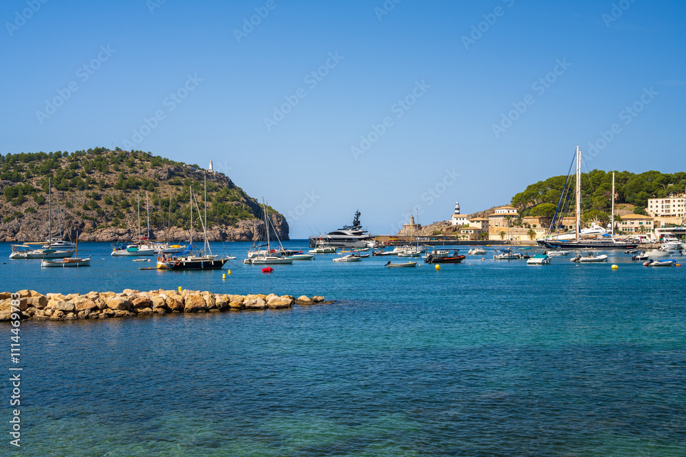 Obraz premium Beautiful coastal view tourist town of Port de Soller. Moored yachts, ships in harbor. Rocky coast, lighthouse. Mallorca, Spain. Balearic Islands