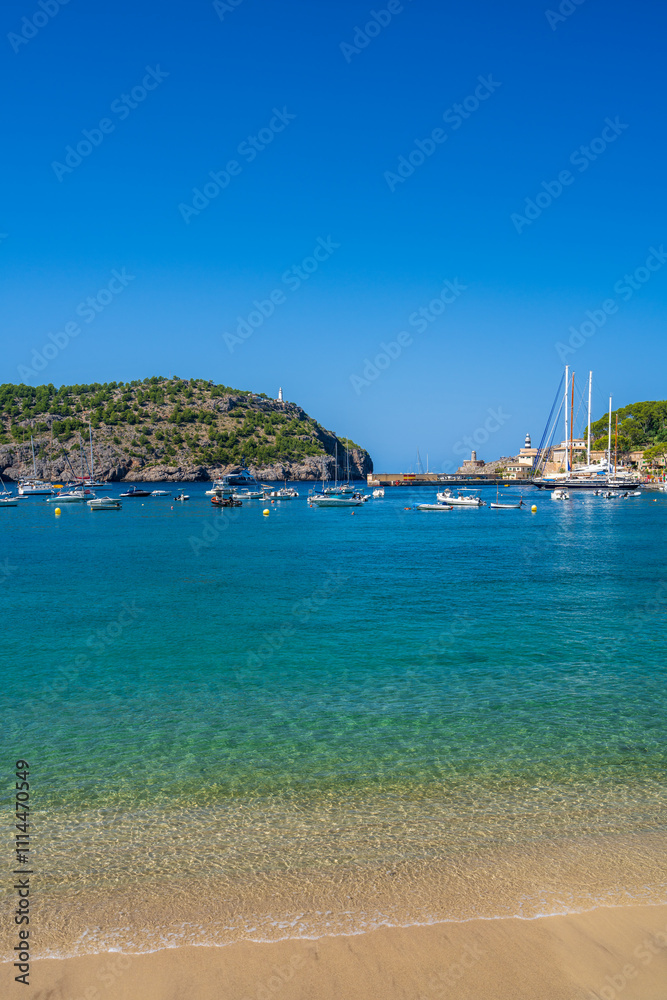 Fototapeta premium Beautiful coastal view tourist town of Port de Soller. Moored yachts, ships in harbor. Rocky coast, lighthouse. Mallorca, Spain. Balearic Islands