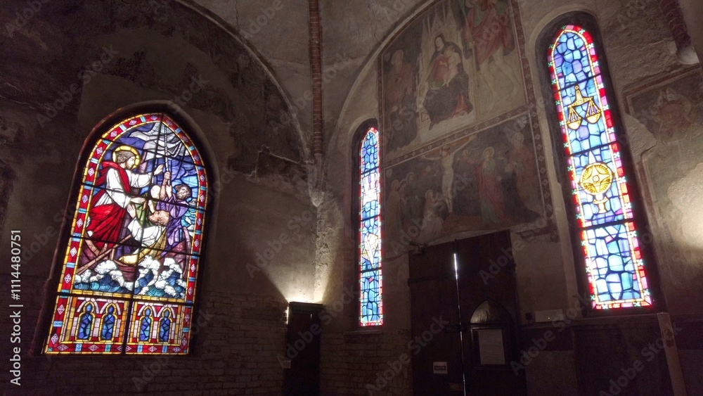 Europe, Italy , Milan 12,04,2024 stained glass window of a Christian church with colored glasses depicting scenes of the spirituality of the Catholic religion in San Cristoforo