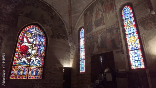 Obraz na płótnie Europe, Italy , Milan 12,04,2024 stained glass window of a Christian church with colored glasses depicting scenes of the spirituality of the Catholic religion in San Cristoforo w salonie