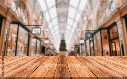 Empty wood table top with supermarket grocery store aisle and shelves blurred background 