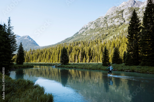 Obraz na plátně A young man crosses the Green River en route to Gannett Peak in Wyoming on July 14, 2024