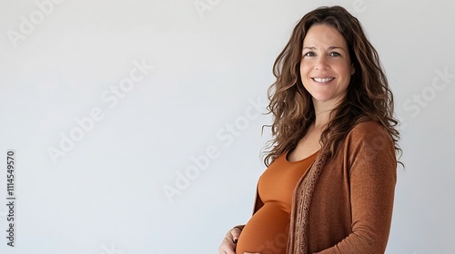 Pregnant woman smiling and holding her belly on a white background