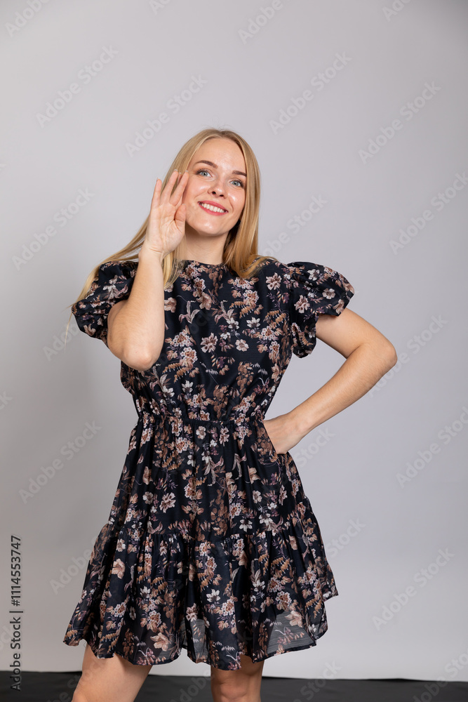 Fototapeta premium Beautiful woman smiling in summer dress on gray background