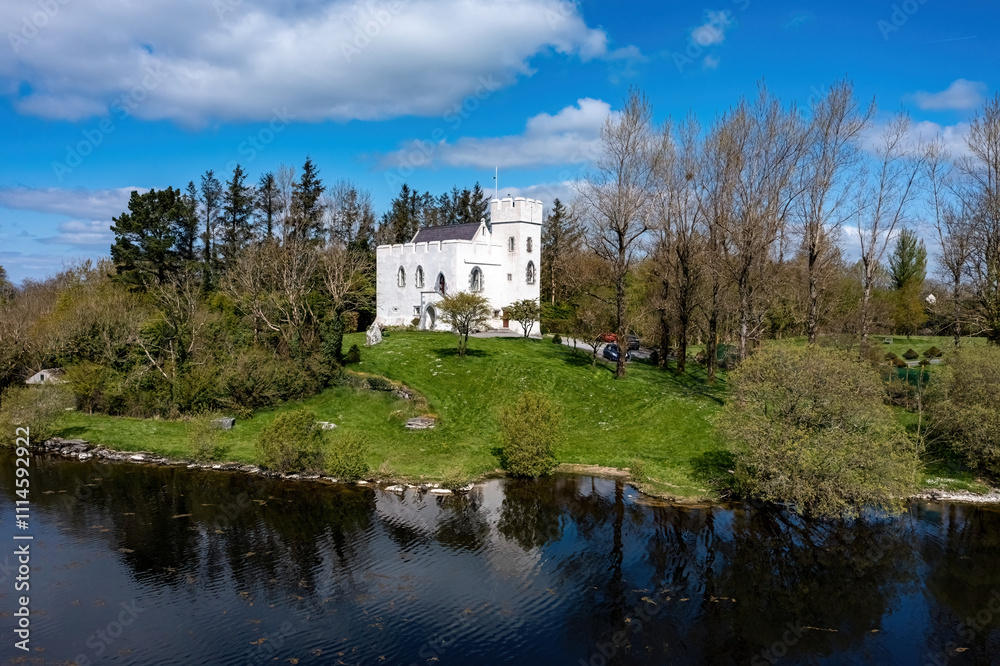 Fototapeta premium Cargin Castle on the shores of Lough Corrib, mirrored in the calm waters on a sunny day