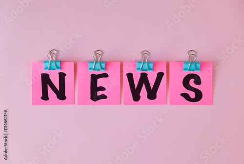 News text on a pink sticker and on pink background. photo