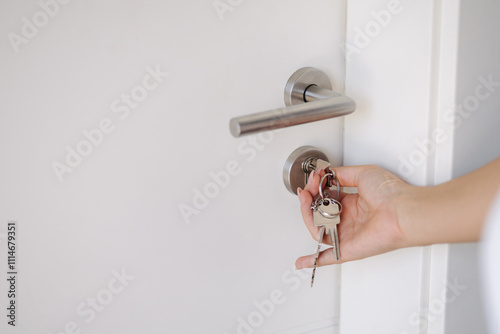 Side view of hand inserting keys into a door lock with a sleek, modern design.