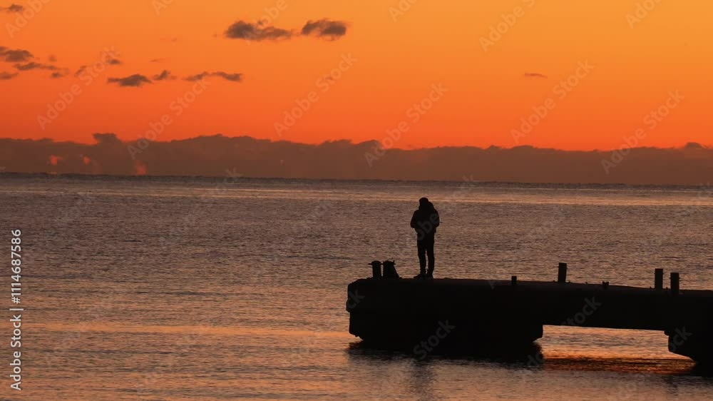 Silhouettes of fishermen against the sunset at the dock. Evening fishing. Silhouettes of fishermen against the sunset at the dock. Evening fishing.
