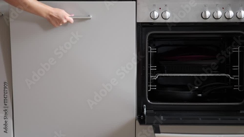 The woman opened the dishwasher after the dishes had been cleaned. Slow motion video