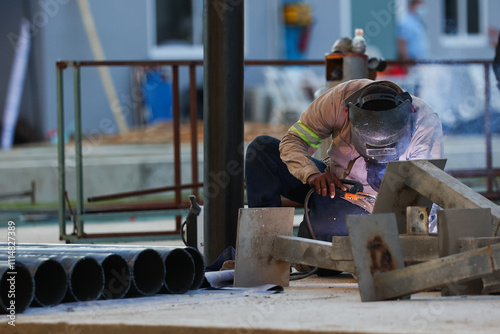 blacksmith welding metal structure at construction site