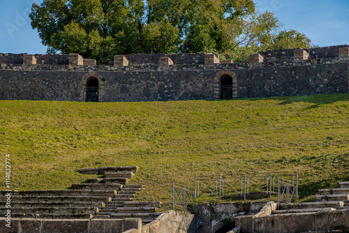 Side view of amphitheatre in pompeii. Collossal view of anfiteatro between the ruins of pompei city close to Naples in italy on a sunny autumn day photo