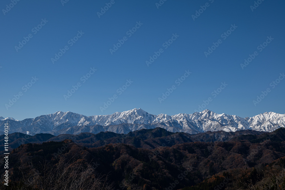 Fototapeta premium 冠雪の北アルプスの山並み 遠望