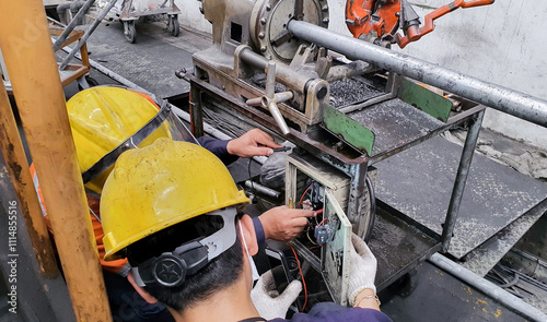 Electricient use voltmeter to measure the voltage of  machine, Maintenence are checking the fault in breakdown machine