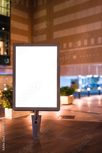 illuminated billboard on the sidewalk in front of the shopping mall