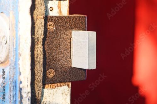 one metal grey brown mortise lock on white wooden door on red background