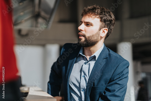 A confident businessman in a blue suit actively engages in a discussion during a professional business meeting, conveying focus and seriousness.