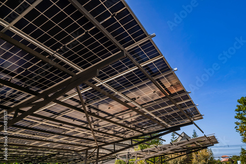 ngineer inspecting solar panel installation on a modern structure, pointing to details while holding a laptop, highlighting sustainable energy solutions, efficient design, and renewable innovation. photo