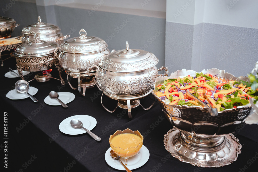 a buffet table with silver plates with food