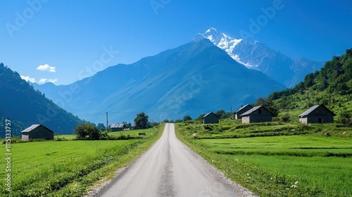 Narrow village road with a view of a distant mountain, traditional stone cottages, and green meadows